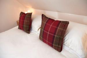 two pillows sitting on top of a bed at The Mews Apartment at Daviot Lodge in Inverness