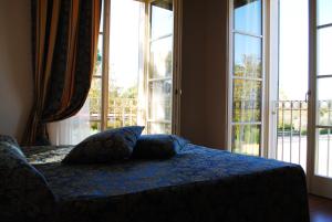 a bed sitting in a bedroom next to a window at Hotel Vedute in Fucecchio