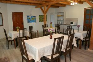 ein Esszimmer mit Tischen und Stühlen sowie eine Küche in der Unterkunft Vila Anna in Sovata