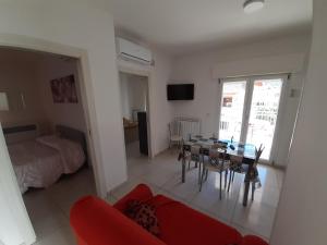 a living room with a red couch and a table at San Marco Beach App Libeccio in Agropoli