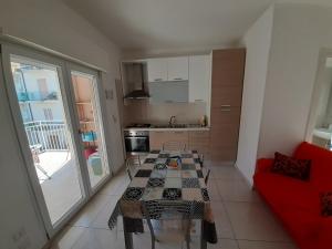 a living room with a table and a red couch at San Marco Beach App Libeccio in Agropoli