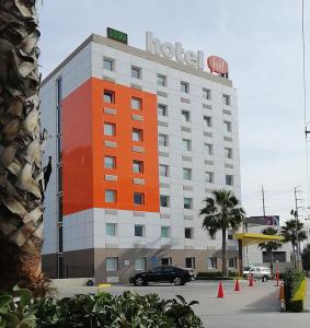 un bâtiment d'hôtel avec une voiture garée devant lui dans l'établissement Hotel Hi! Santa Catarina, à Monterrey
