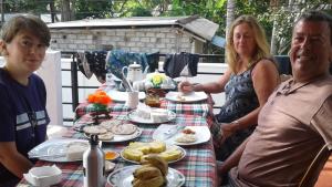 um grupo de pessoas sentadas à mesa com comida em Paradise Beach House em Talalla South