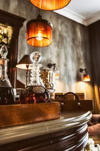 a bottle of whiskey on a table with a lamp at The Pand Hotel - Small Luxury Hotels of the World in Bruges