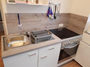 cocina pequeña con fregadero y fogones en 30 qm Apartment super zentral in Melsungen, en Melsungen