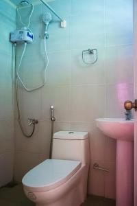 a bathroom with a pink toilet and a sink at CED Garden in El Nido