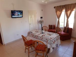 Apartamento en salta في سالتا: غرفة طعام مع طاولة وكراسي وتلفزيون