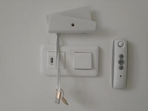 a white wall with an electrical outlet and a controller at Les Gîtes du Château de Passillé in Parigné
