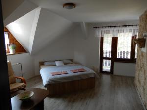 sypialnia z łóżkiem, stołem i oknami w obiekcie Penzion Bolero w mieście Moravská Nová Ves