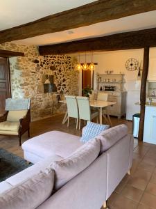 a living room with a couch and a kitchen at Gîtes Perruchet in Castelnavet