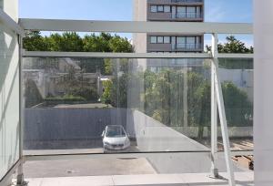 un coche sentado en una mesa de cristal en un balcón en Depto nuevo, luminoso, excelente ubicación, ideal para descansar. en Mar del Plata