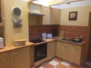 a kitchen with wooden cabinets and a sink and a clock at Haus 32 in Wismar