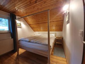Cama en habitación con techo de madera en Veronica's place in the mountains, en Cerklje na Gorenjskem