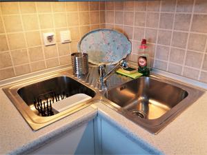 a kitchen sink with a dish strainer in it at Potamos apartment with view in Potamós