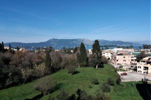 a green hill with buildings and a city at Potamos apartment with view in Potamós