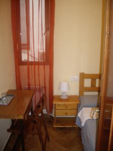 1 dormitorio con cama, escritorio y mesa en Hostal Pacios, en Madrid