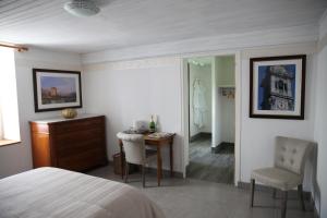 een slaapkamer met een bed, een tafel en een stoel bij La Grange Ô Belles in Champfrémont