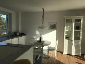 a kitchen with a table and chairs in a room at Attika Ferienwohnung in Freiburg -Gundelfingen mit großer Dachterrasse in Gundelfingen +5 photos