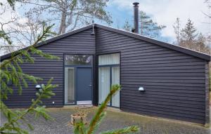una casa nera con una grande porta a vetri di Amazing Home In Grsted With Kitchen a Græsted