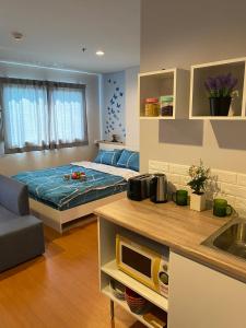 a bedroom with a bed in the middle of it at Lumpini seaview cha-am By Greenview in Ban Sahakham