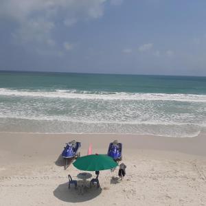 a beach with a table and chairs and an umbrella at Sunrise Resort- Koh Phangan - SHA Extra Plus in Haad Rin