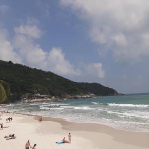 a group of people on a beach near the ocean at Sunrise Resort- Koh Phangan - SHA Extra Plus in Haad Rin