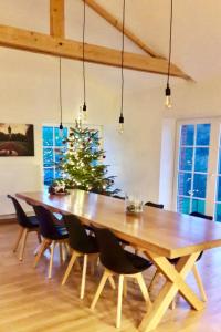 a large wooden table with chairs and a christmas tree at Gite La Petite Beurrerie des Ardennes in Celles