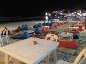 a group of tables and chairs on the beach at night at Sunrise Resort- Koh Phangan - SHA Extra Plus in Haad Rin