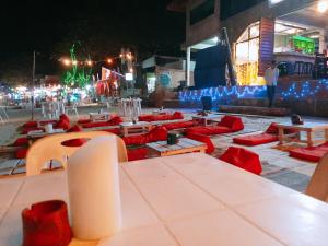 a group of tables and chairs with red seats at night at Sunrise Resort- Koh Phangan - SHA Extra Plus in Haad Rin