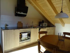 a kitchen and dining room with a table and a fireplace at Ferienwohnung Molopark im Haus Ecker in Murnau am Staffelsee