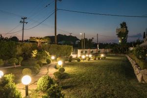 a garden with lights on the grass at night at Sun Maris in Faliraki