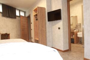 ein Schlafzimmer mit einem Bett und einem TV an der Wand in der Unterkunft Albergo Meublè Stelvio in Tirano
