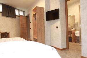 a bedroom with a bed and a tv on a wall at Albergo Meublè Stelvio in Tirano