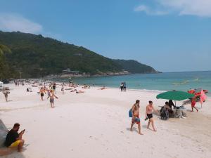 a group of people on a beach with the ocean at Sunrise Resort- Koh Phangan - SHA Extra Plus in Haad Rin