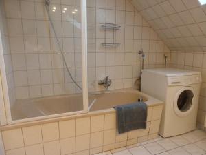 ein Badezimmer mit einer Badewanne und einer Waschmaschine in der Unterkunft Meine Ferienwohnung Seeburg 1 in Seeburg + 14 Fotos