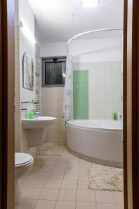 łazienka z wanną, toaletą i umywalką w obiekcie IRIS LUXURY w mieście Olimp