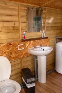 uma casa de banho com um lavatório e um WC em Sleeps-6 lakeside bell tent - Suffolk em Sudbury