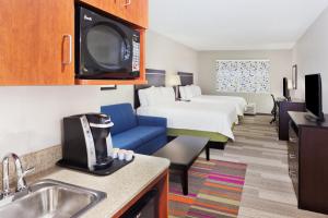 a hotel room with a bed and a kitchen with a sink at Holiday Inn Express Hotel & Suites Montgomery Boyd-Cooper Parkway by IHG in Montgomery