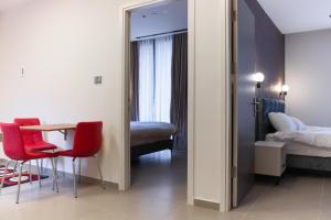 Zimmer mit einem Tisch und 2 Stühlen sowie einem Schlafzimmer in der Unterkunft Amwaj Apartments in Nazareth