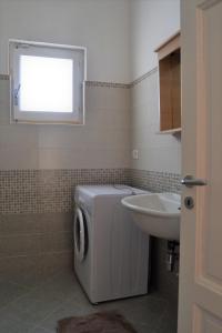 een badkamer met een wasmachine en een wastafel bij Villa Graziella in Ostuni