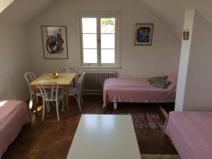 a room with two beds and a table and a window at Klinttorget 1 in Visby