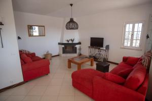 a living room with two red couches and a fireplace at Villa De Hofnar in Soalheira