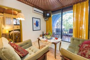 a living room with a table and two couches and a table at Havaya Ba Nof Lodge in Rosh Pinna