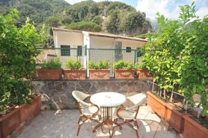 una mesa y sillas en un balcón con plantas en Villa Adriana Amalfi, en Amalfi