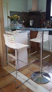 a kitchen with two white chairs and a table at A CLAIR MATIN in Estang