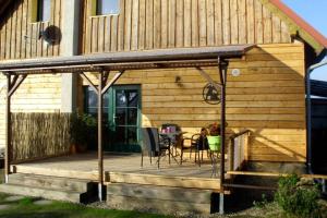 a wooden deck in front of a house at Entspannen im Dorf am See in Zahren +7 photos