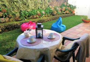 een tafel met kopjes en schotels op een patio bij Surf & Guest Lorena´s House in Ribeira Grande