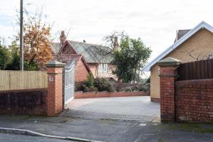 a house with a gate and a brick driveway at The Garage @ The Old Vicarage in Swansea