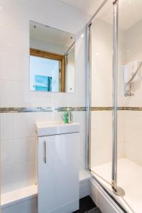 La salle de bains est pourvue d'une douche, d'un lavabo et d'un miroir. dans l'établissement The Garage @ The Old Vicarage, à Swansea
