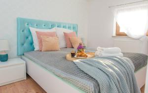 een bed met een blauw hoofdeinde en een dienblad met handdoeken bij EASY RENT Apartments - LOFT in Lublin